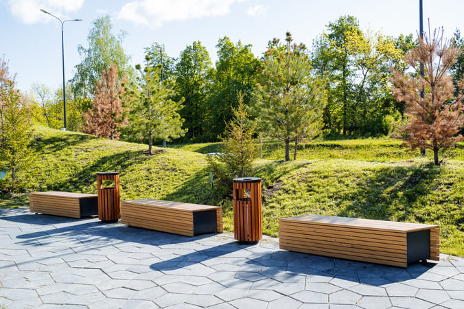 Beautiful landscape design of the city park, a pleasant place for walks and recreation of citizens, wooden benches for sitting, a sidewalk in the park