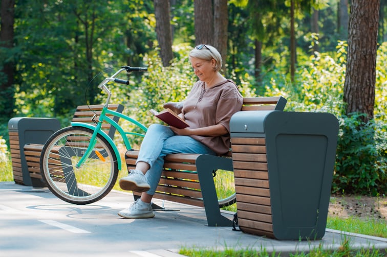 Woman in casual sitting wooden bench outdoors. - AdobeStock_526256306 - June 2024 Blog